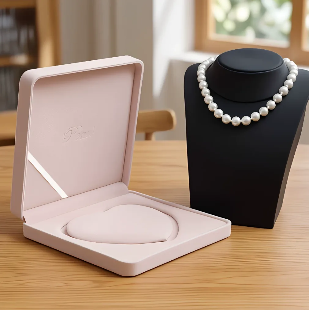 Pink pearl necklace presentation box beside a white freshwater pearl necklace display