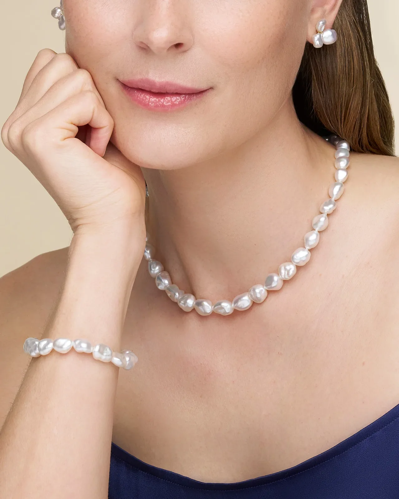 Model wearing a matching white baroque pearl necklace, earrings and bracelet