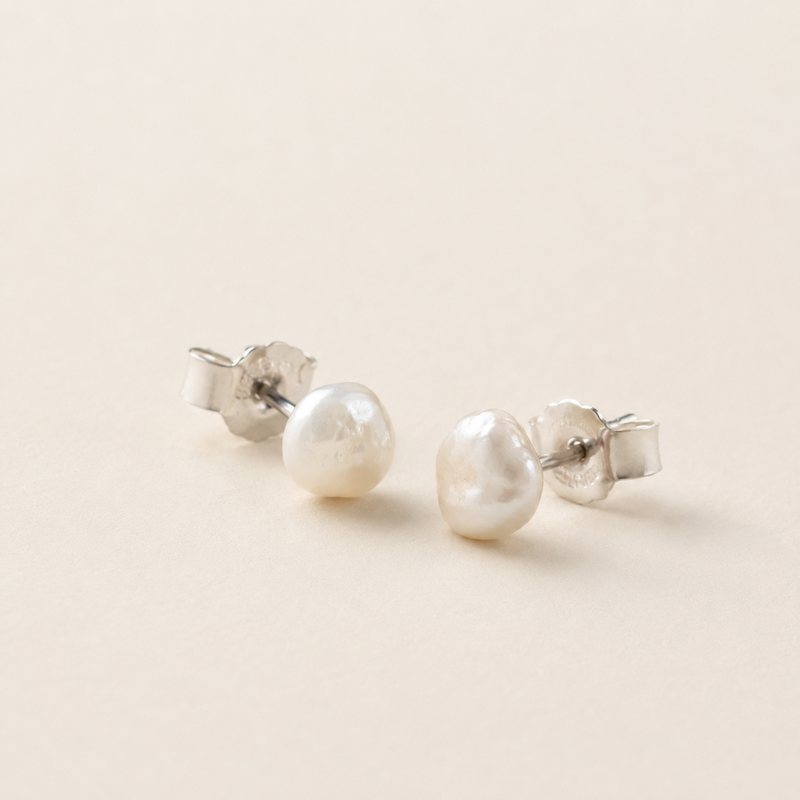 Example of small freshwater pearl stud earrings for product presentation. Image generated for layout use.